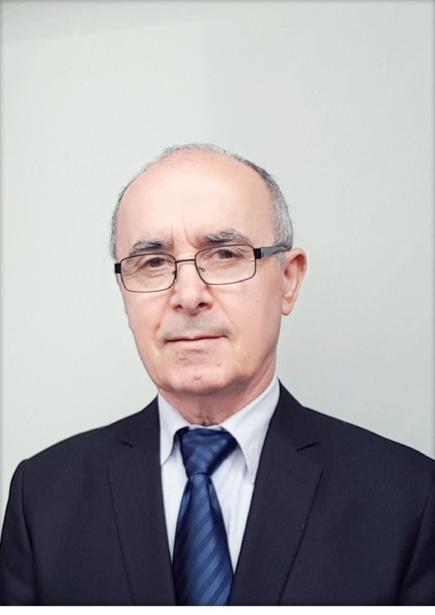 Portrait of Yonan Roil in a dark suit and blue tie